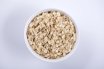 Top view of white bowl with oats on white background. Isolated.