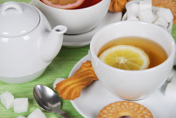 grapefruit and lemon tea with sweet cookies and sugar cubes