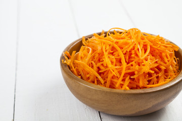 Grate  carrots in a bowl