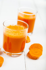 Carrot juice on a wooden table.