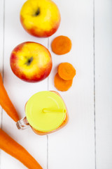 Apple-carrot juice on a wooden table.