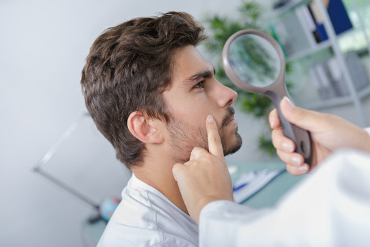 Close-up Of Doctors Hands Checking Mans Moles