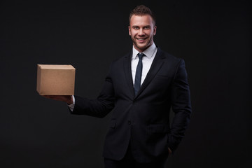 Portrait of young businessman holding a box