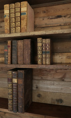 antique books on old wooden shelf.