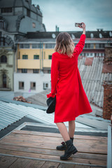 Girl in red posing on the roof of old city