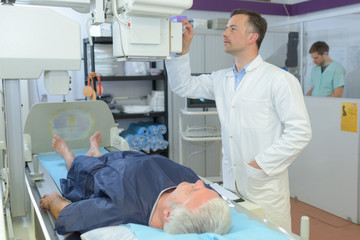 Fototapeta premium female doctor with male patient undergoing scanner