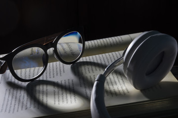 Eyeglasses on book in dark light.
