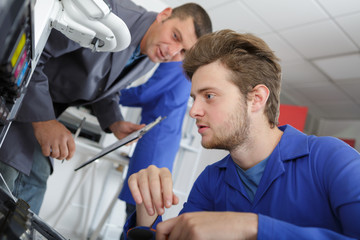 Obraz premium young man repairing a printer