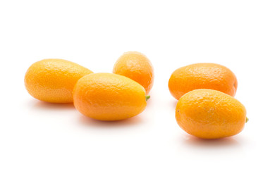Five kumquat isolated on white background.