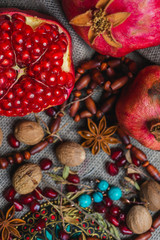 Juicy aromatic pomegranate on the table with a decor of national ornaments.