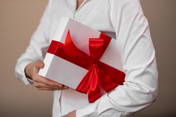 A woman in a white shirt is holding a gift