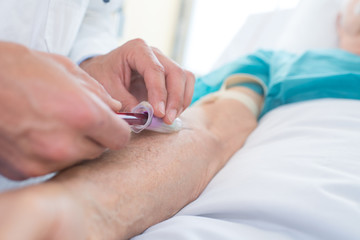 medical technologist drawing blood sample from arm for laboratory test