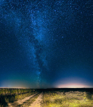 Night Starry Sky Above Country Road In Countryside And Green Field