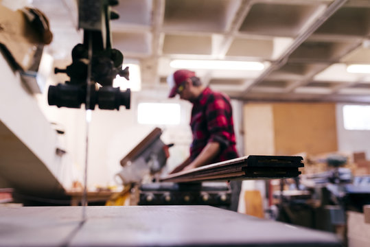 Unfocused carpenter carrying wood