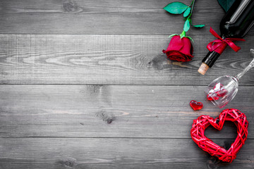 Celebrate Valentine's day. Wine, glasses, red rose, heart sign, gift box on dark wooden background top view copy space