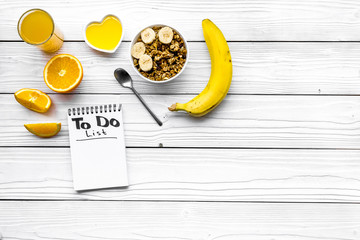 Start the day the right way. Healthy breakfast oatmeal with fruits and planning the day. White wooden background top view copy space