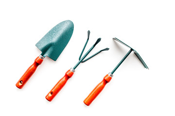 Gardening tools: spade, fork, hand cultivator, hoe on white background top view