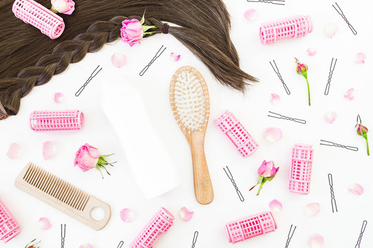 Tools for hair styling, shampoo and roses flowers on white background. Beauty composition. Flat lay, top view
