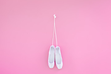 Ballet pointe shoes on pink background top view copy space