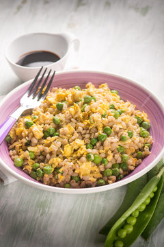 barley risotto woth green peas scramble eggs and soy sauce,  selective focus
