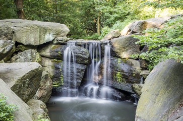 Fototapeta na wymiar North Woods Water Fall, silk water effect at Central Park, New York City, NY, USA