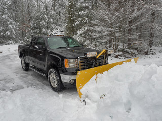 snow plow clearing a parking lot after  storm