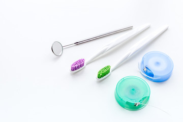 Tools for oral cavity hygiene. Brushes, floss, dental mirror on white background copy space