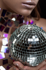 Beautiful young caucasian woman holding disco ball