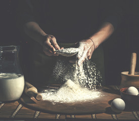 Man preparing bread dough on wooden table in a bakery close up. Preparation of Easter bread.
