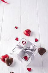 candies hearts and gift box on wooden board,