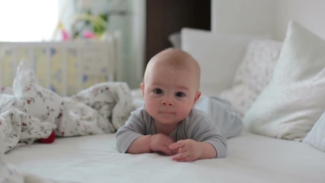 Little cute baby boy, playing with toys at home, smiling at camera, wintertime