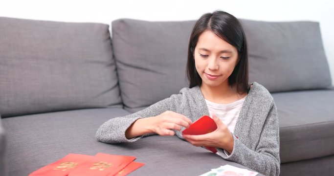 Woman putting banknote into lunar new year red packet