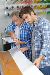 Naklejka na ściany i meble workers with a large printer format inkjet working