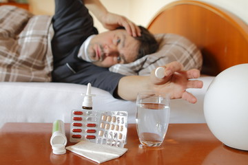 Mann mit Fieber im Bett, Medikamente