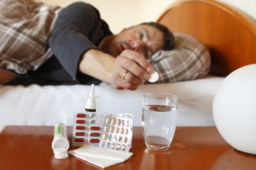 Mann wirft Tablette in Glas, Fieber