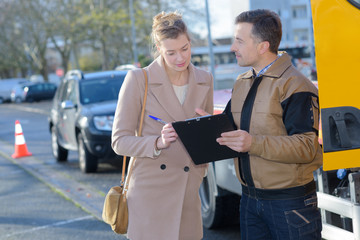 Woman signing paperwork for recovery driver