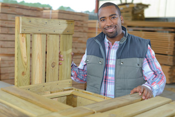 smily man drilling and measuring wood for deck