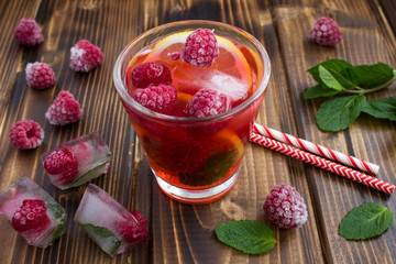 Homemade lemonade with raspberries and  lemon on the  wooden background