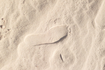 Fototapeta na wymiar The dried footprint in the sand. Footprint on the dead desert. Footprints in the sand, the sea, the beach