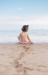 Little girl playing on a tropical beach