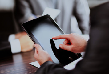 Businessman holding digital tablet at meeting.