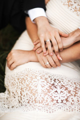 Hands of the bride and groom on the dress