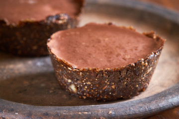 Vegan mini cakes made with walnuts, dates, caramel creme and covered with chocolate