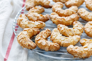 Almond crescent cookies on a metal grid.