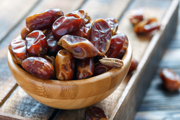 Delicious dried dates in a wooden bowl.