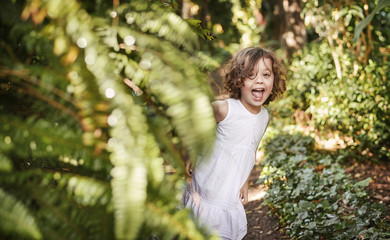 Little cute girl having fun in a tropical garden