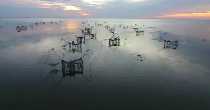 4k aerial movie of Thai fisherman Catching Fish with Large fishing net in the Morning at Ban Pak Pra -Talay Noi Lake, Phatthalung, Thailand