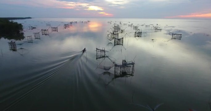 4k aerial movie of Thai fisherman Catching Fish with Large fishing net in the Morning at Ban Pak Pra -Talay Noi Lake, Phatthalung, Thailand