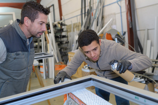 apprentice glazier and mentor in factory workshop