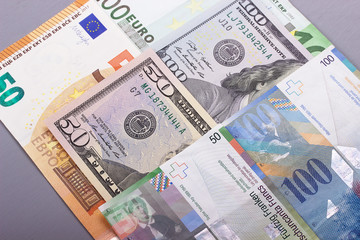 100 euro 50 dollar, swiss franc gray background.